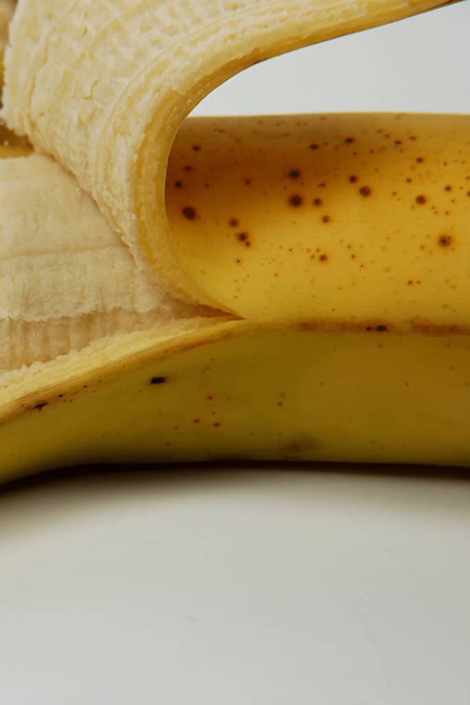A banana with yellow skin and brown spots is ripe