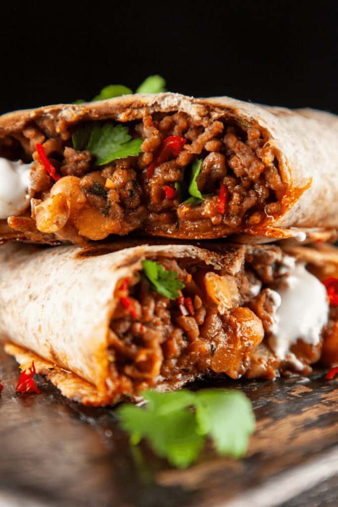 Add less sauce or make the sauce thicker before adding it to the burrito