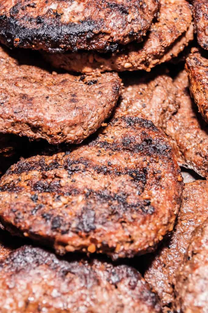 To prevent burgers from burning on the outside in a frying pan use medium to medium-high heat and uniform burgers. Also make sure to flip the burgers at the right time