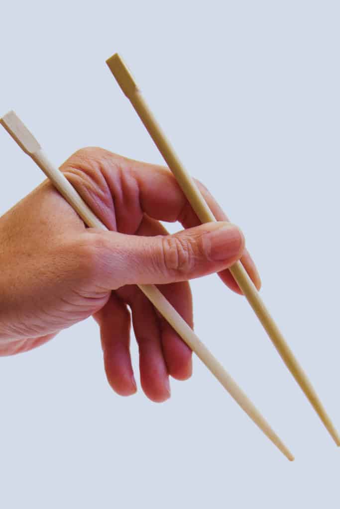 Two sticks Resting between your Thumbs