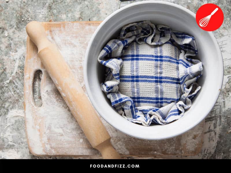 A damp kitchen towel is a good alternative to plastic wrap to cover dough.