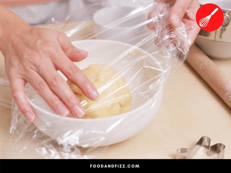 Covering cookie dough in plastic wrap before chilling in the fridge prevents them from losing moisture and drying out.