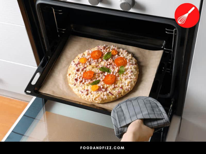 If you don't have a tray, you can still put your pizza in the oven. Make sure to use parchment paper to ensure even and proper cooking.