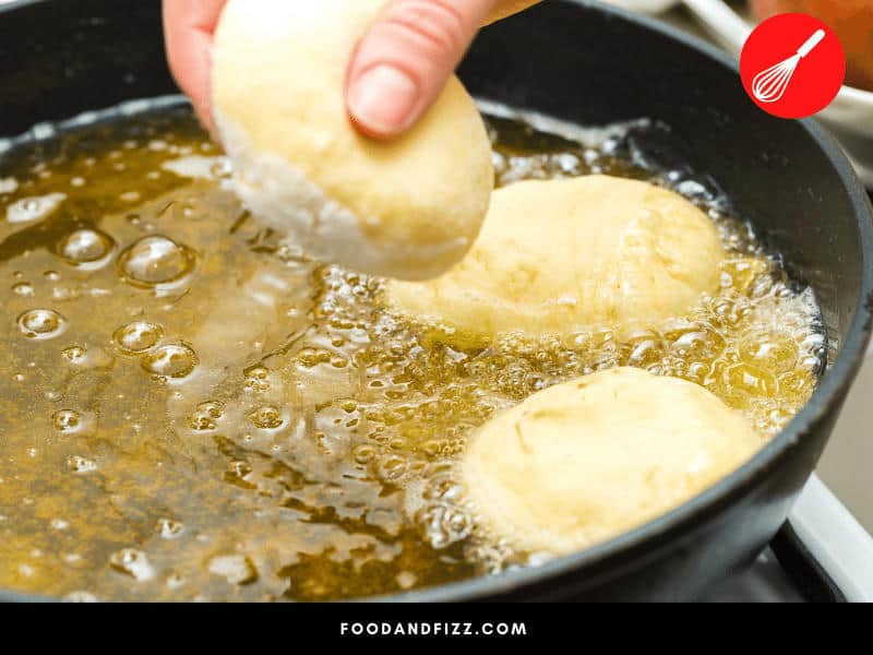 One way to cool down oil while frying is to add cold food to the pan. This brings the temperature down quickly.
