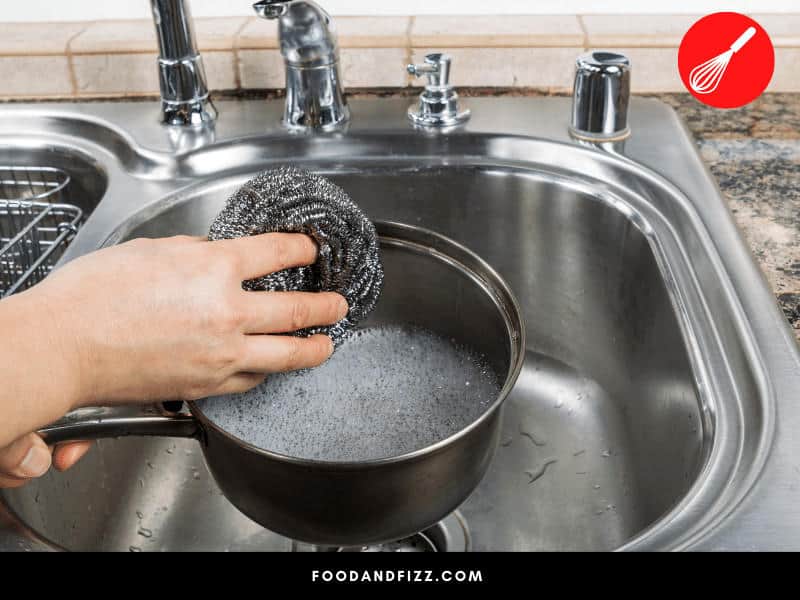 Soak pan in warm, soapy water until the mold loosens. When it loosens, it can easily be scrubbed off with gloves and a scrubbing pad.