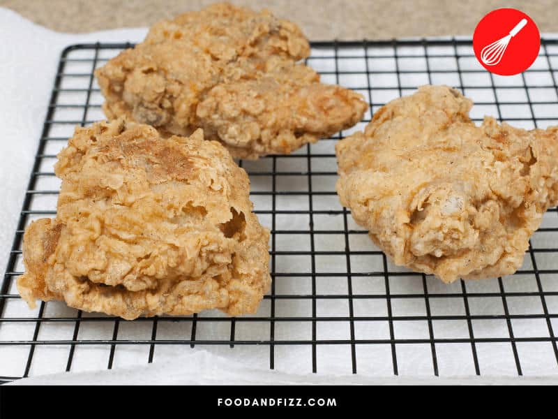 Using a wire rack over a baking sheet is one of the ways to dry fried chicken without using paper towels.