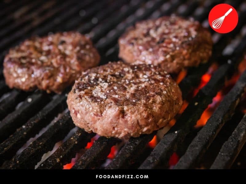 Frozen hamburger patties takes about 20 minutes to cook through, though it depends on how hot the grill is and how thick the patties are.