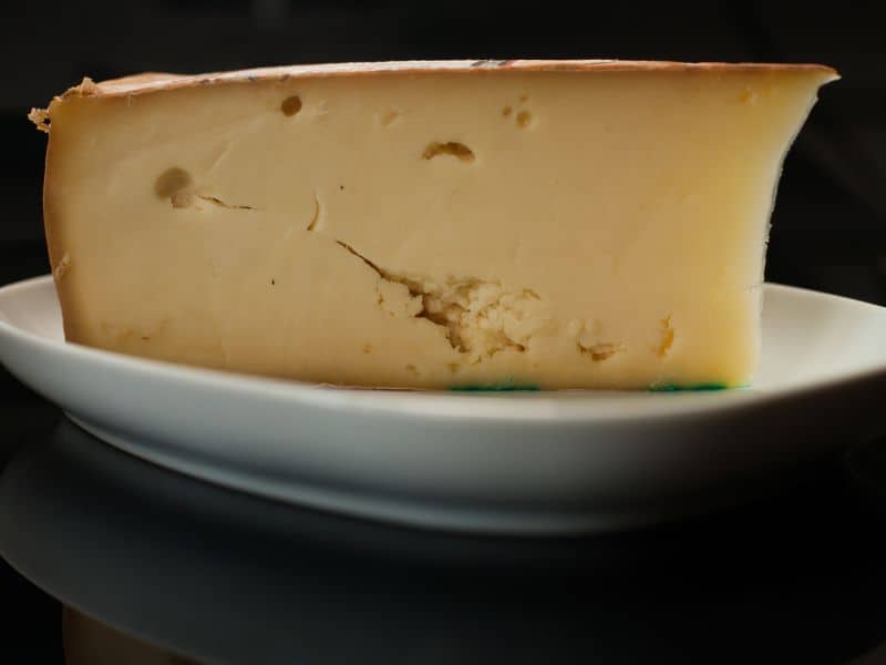 Fontina cheese is light yellow in color with holes, which are called eyes.
